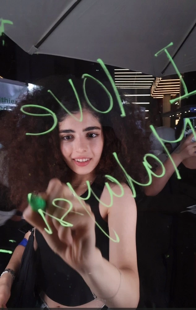 Smiling guest writing on the glass of the Simple interactive booth with a marker