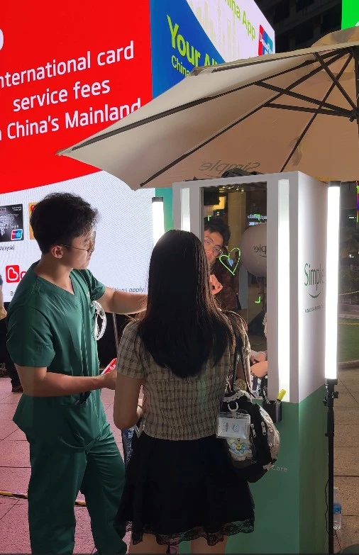 Attendees gathered around the Simple video booth in Bukit Bintang at night