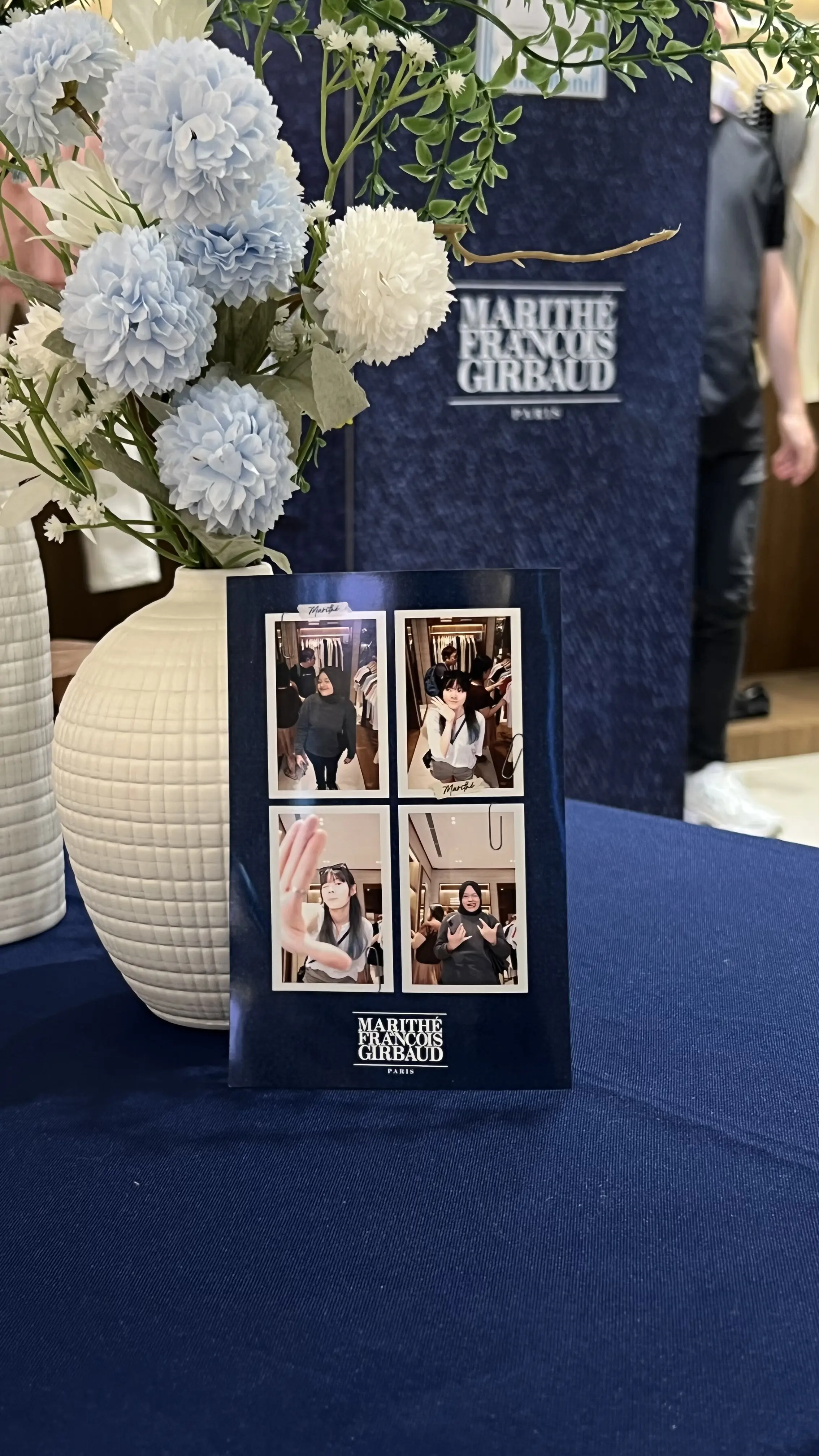 Branded photo print displayed beside blue and white flowers on the event table