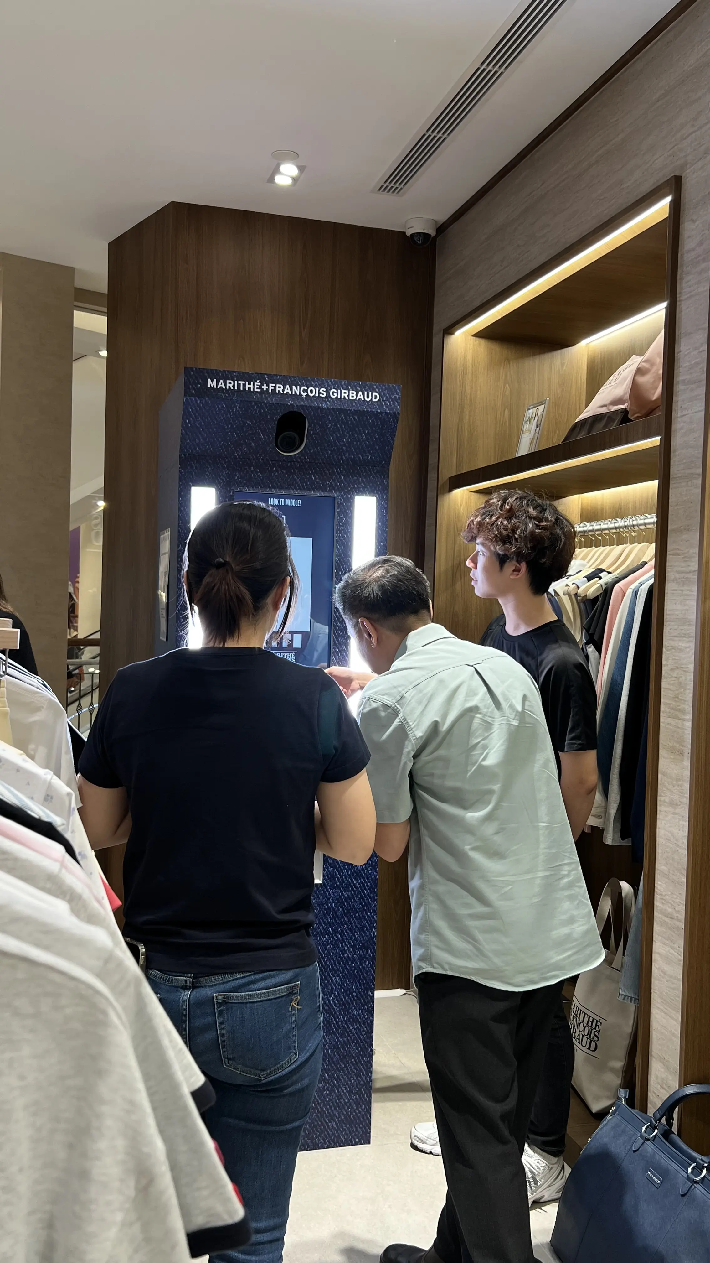Shoppers using the Marithé + François Girbaud photo booth inside the boutique