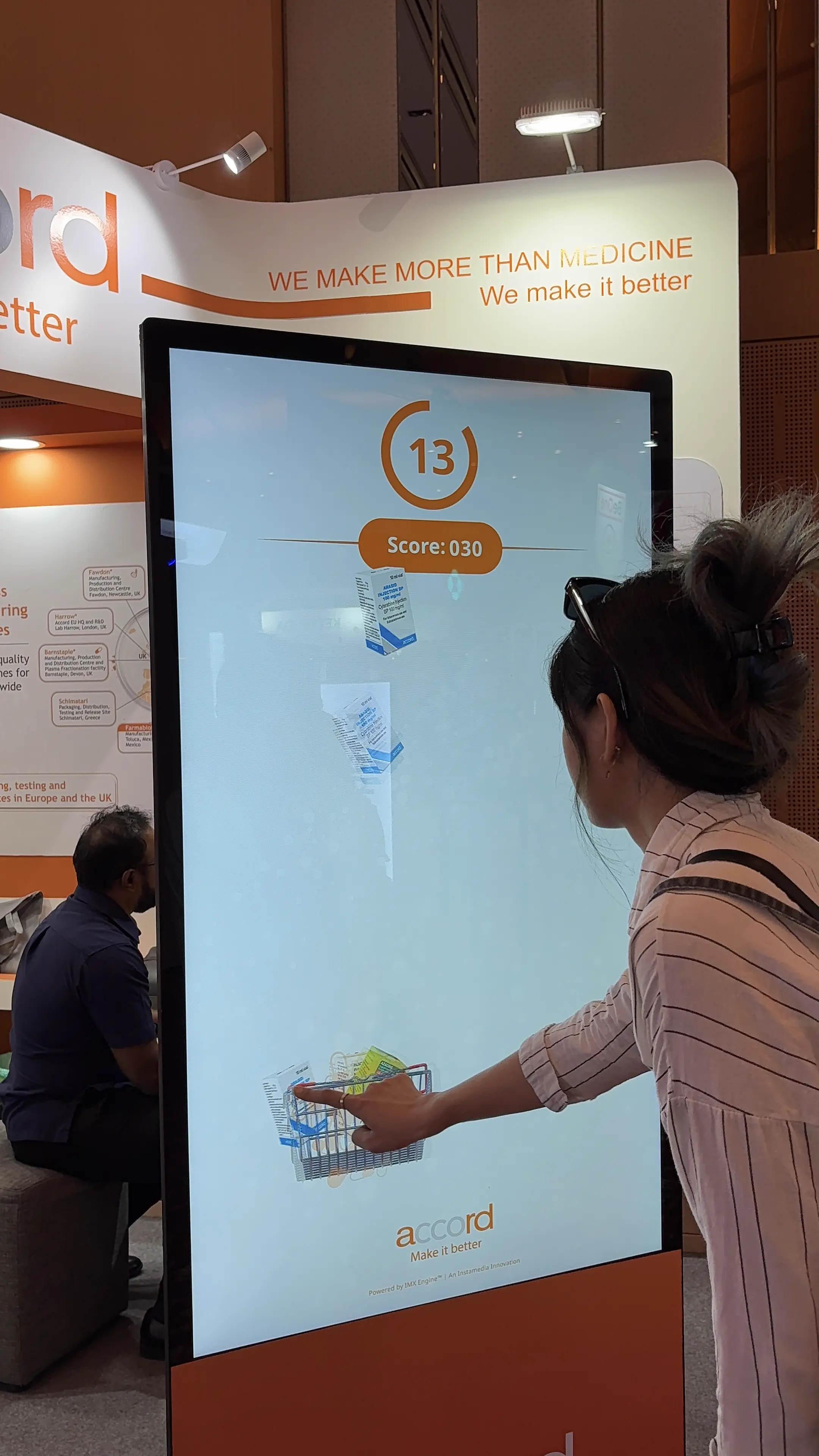 Attendee moving the on-screen basket to catch falling medicine boxes