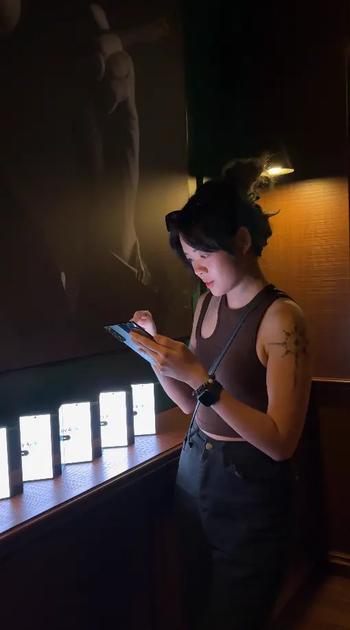 Guest using a Galaxy phone beside a row of glowing phone displays
