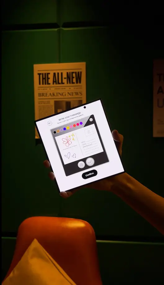 Guest holding a Samsung foldable showing the postcard confirm screen
