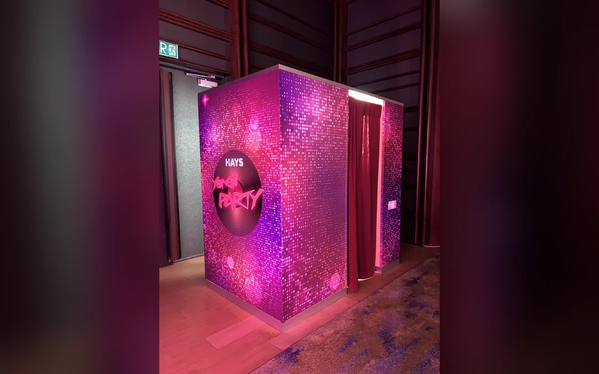 HAYS Year End Party photo booth wrapped in pink disco sequins with a vinyl-record logo