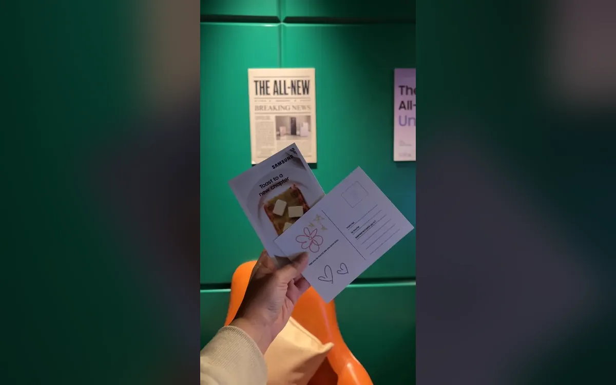Hand holding printed Samsung watch party postcards with a hand-drawn flower message