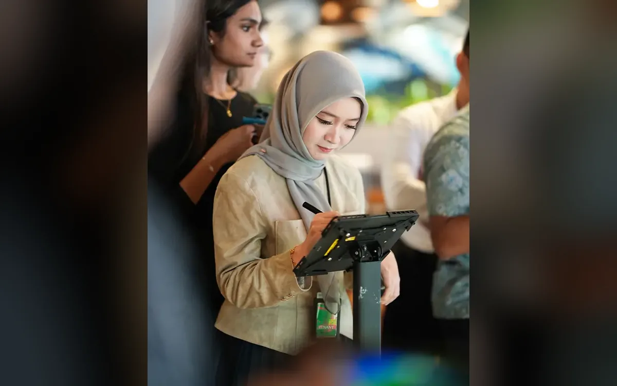KWAP employee colouring a digital flower on an iPad station at the appreciation event