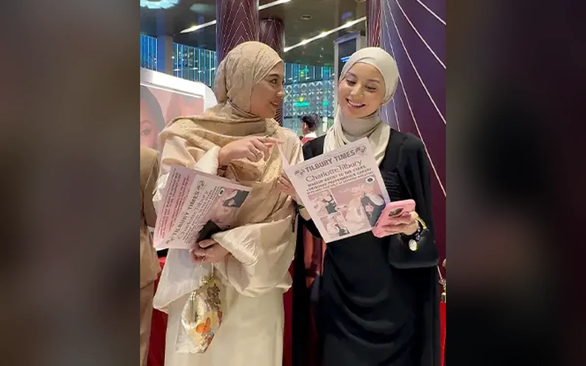 Guests reading their Charlotte Tilbury A3 newspaper-style photo prints at the launch