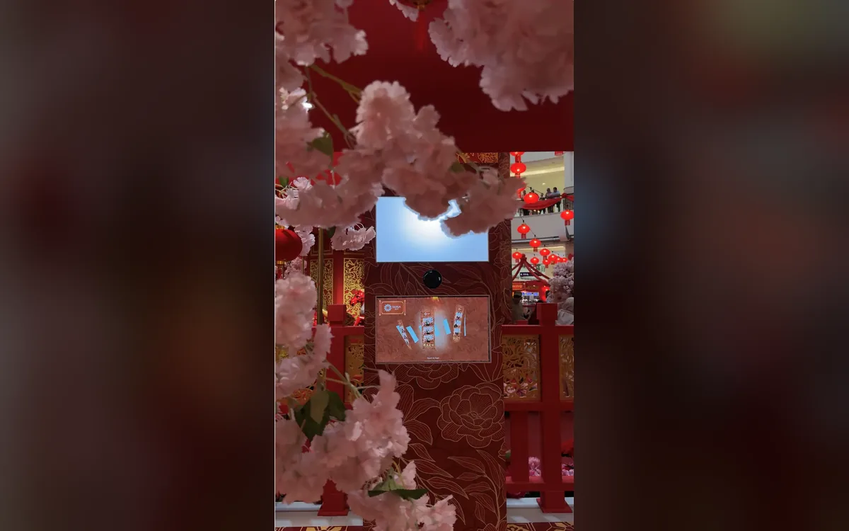 Suria KLCC Chinese New Year photo booth framed by pink cherry blossoms and red lanterns