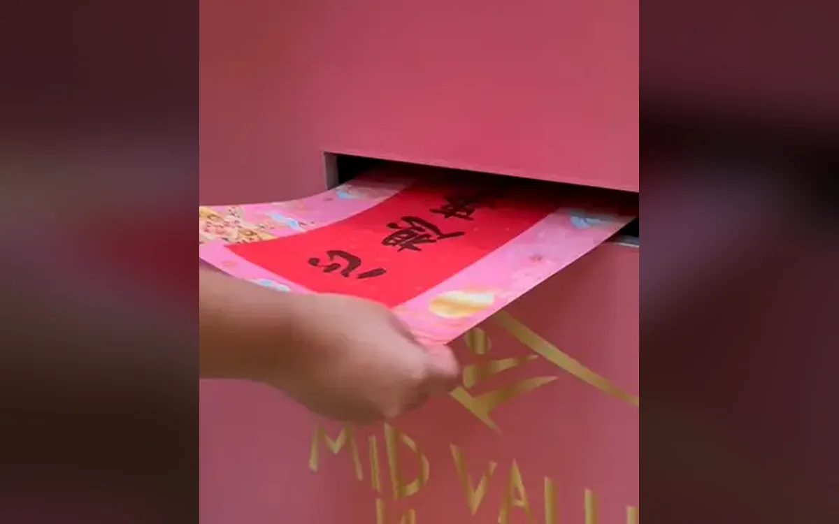 Personalised Chinese New Year greeting print coming out of the Mid Valley calligraphy kiosk