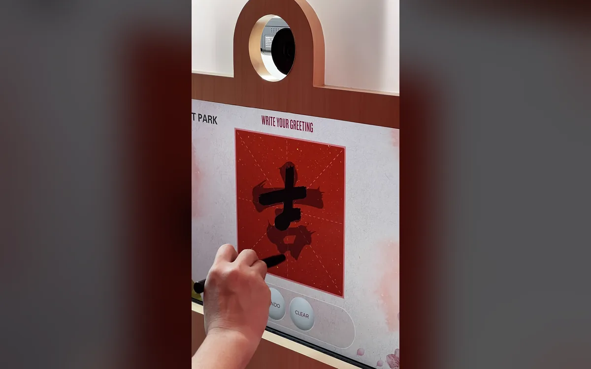 Hand writing a Chinese New Year luck character with a stylus on the Mitsui Outlet Park KLIA calligraphy booth