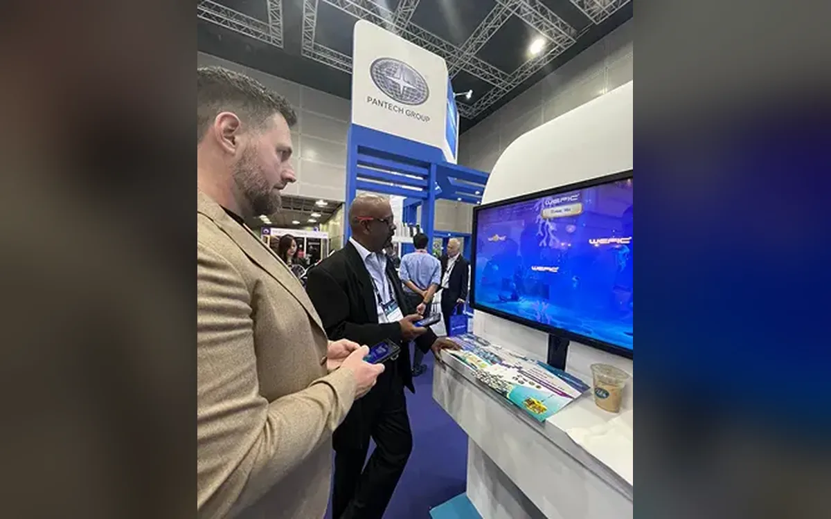 Visitors playing the Wefic multiplayer game on their phones at the OTC Exhibition booth