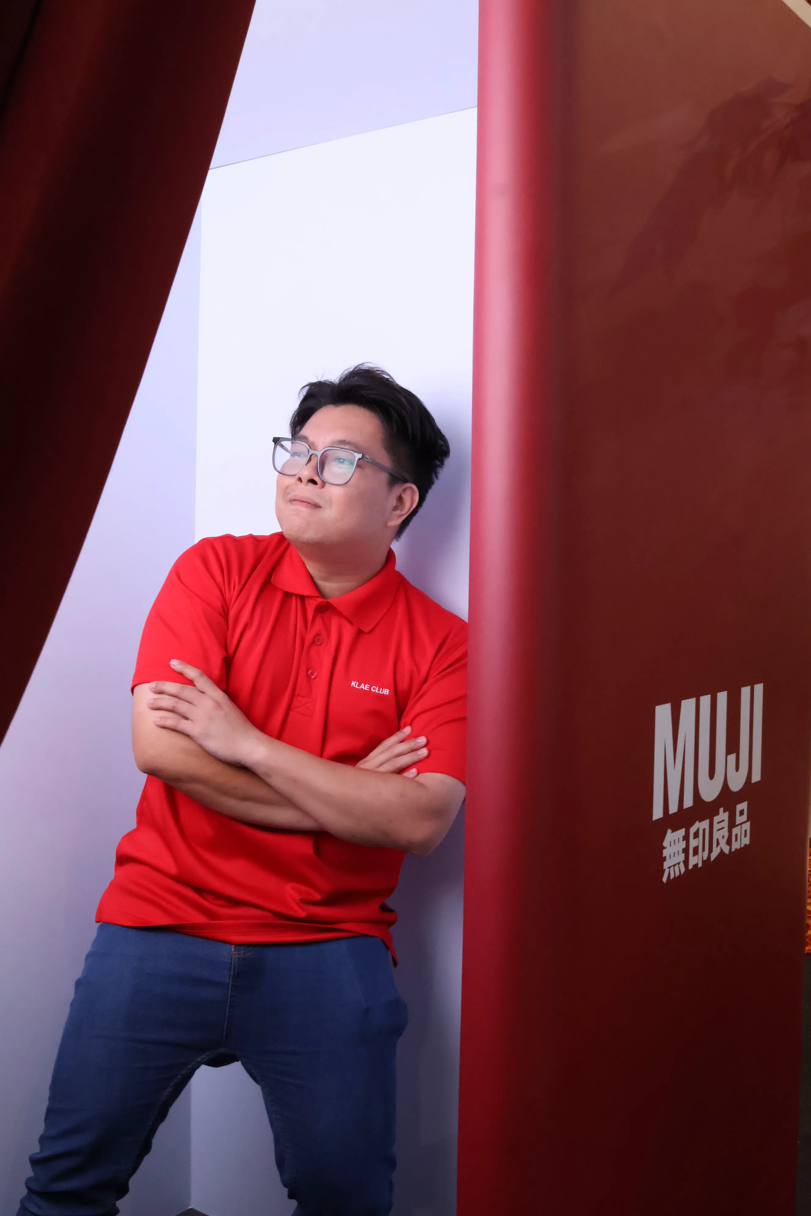 Guest posing with arms crossed inside the red MUJI photo booth