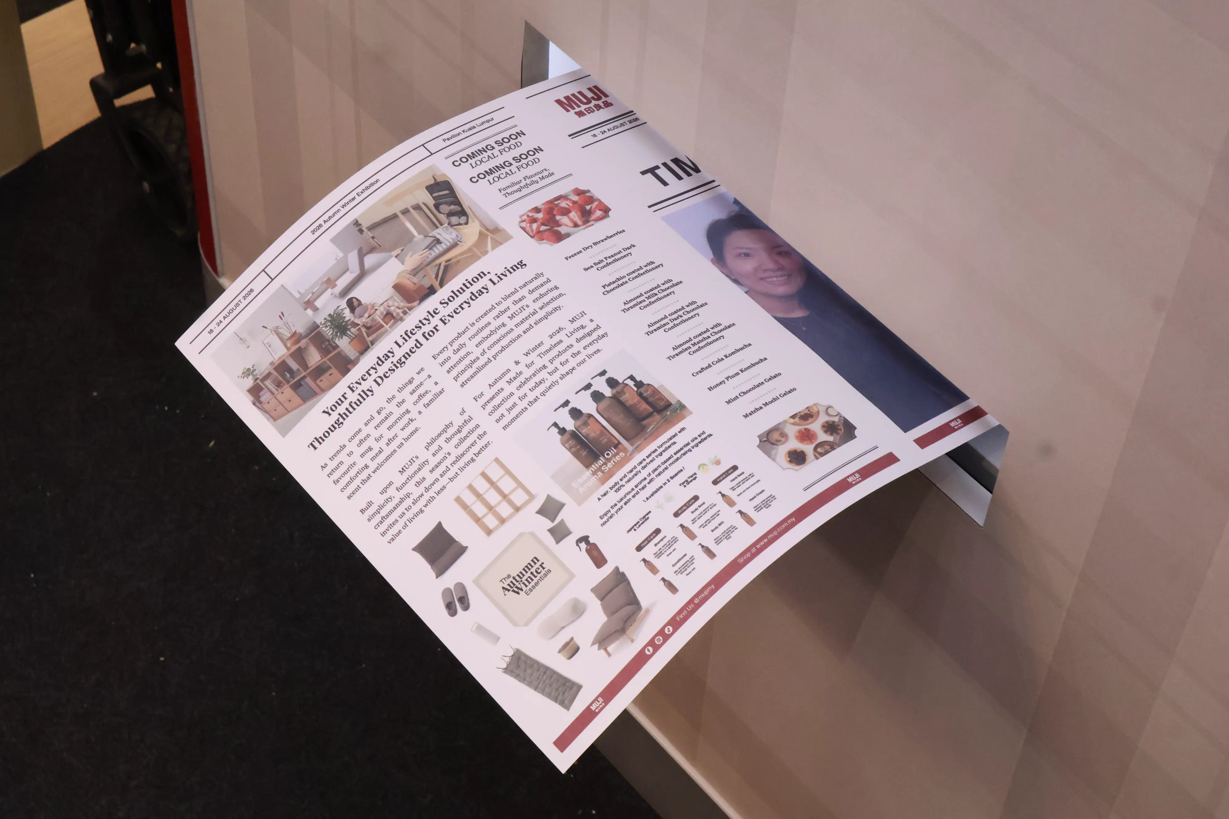 Newspaper-style MUJI photo print coming out of the booth print slot