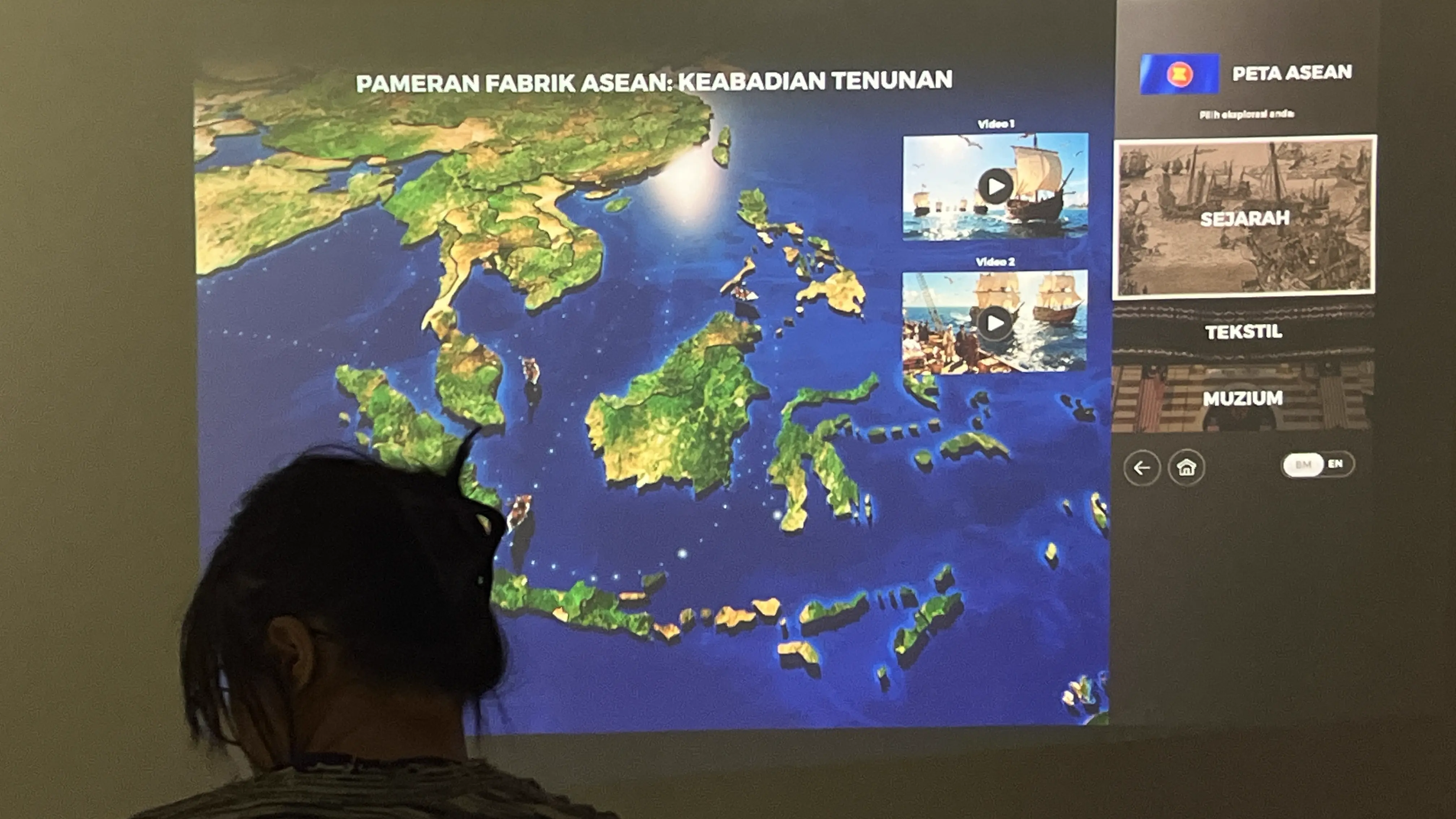 Visitor exploring the Pameran Fabrik ASEAN interactive map with history videos