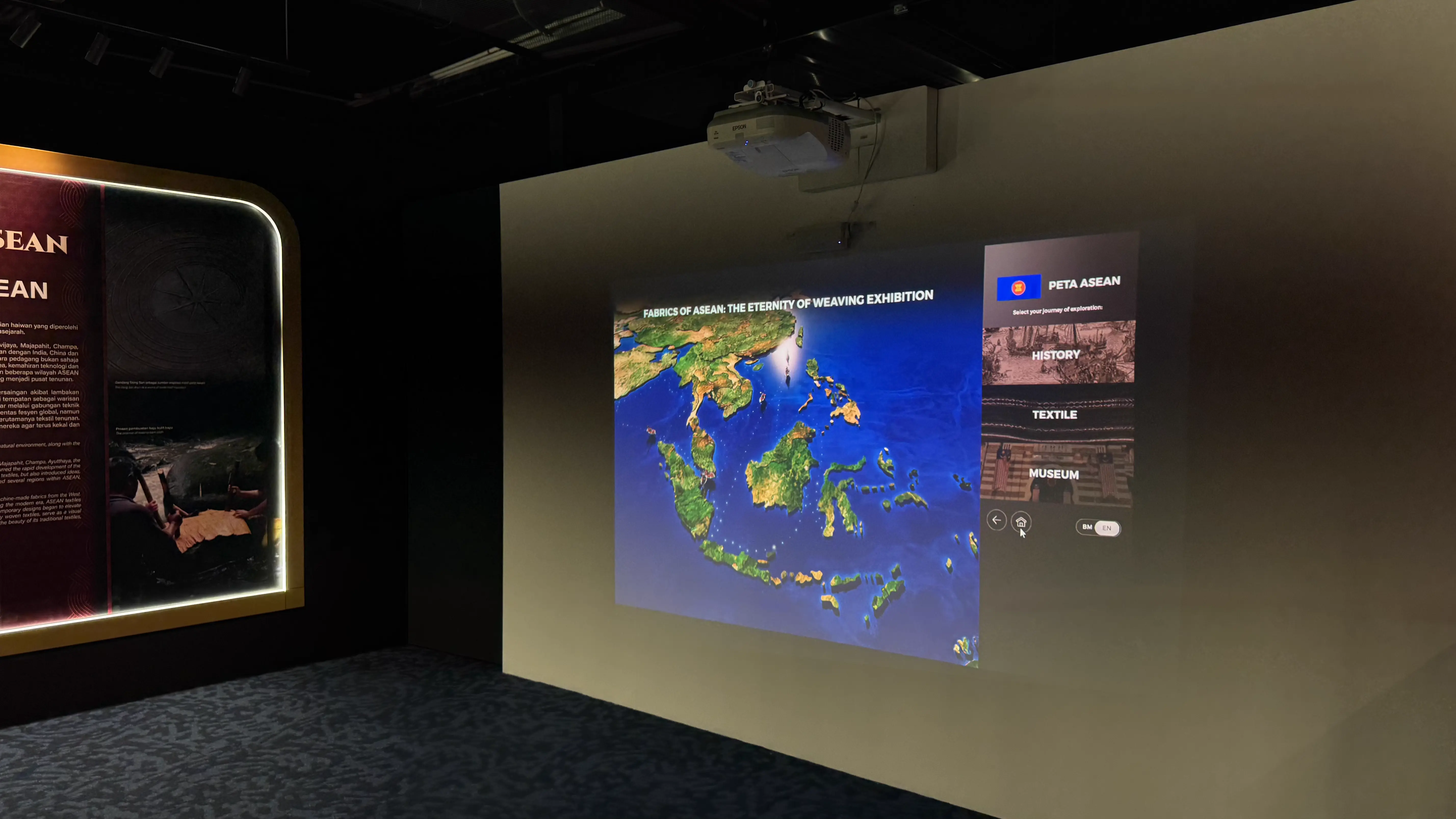 Projected Fabrics of ASEAN interactive map beside an illuminated exhibition panel