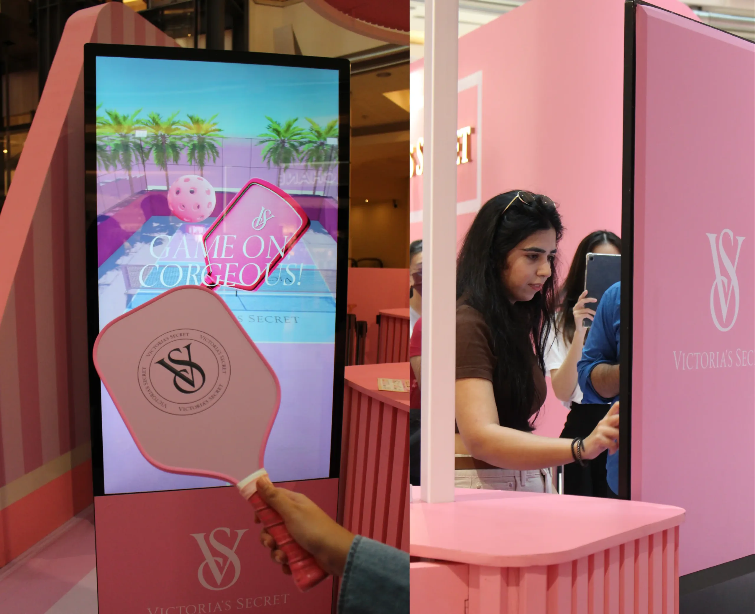 A pink pickleball-themed digital game screen beside a woman photographing herself at a branded kiosk.