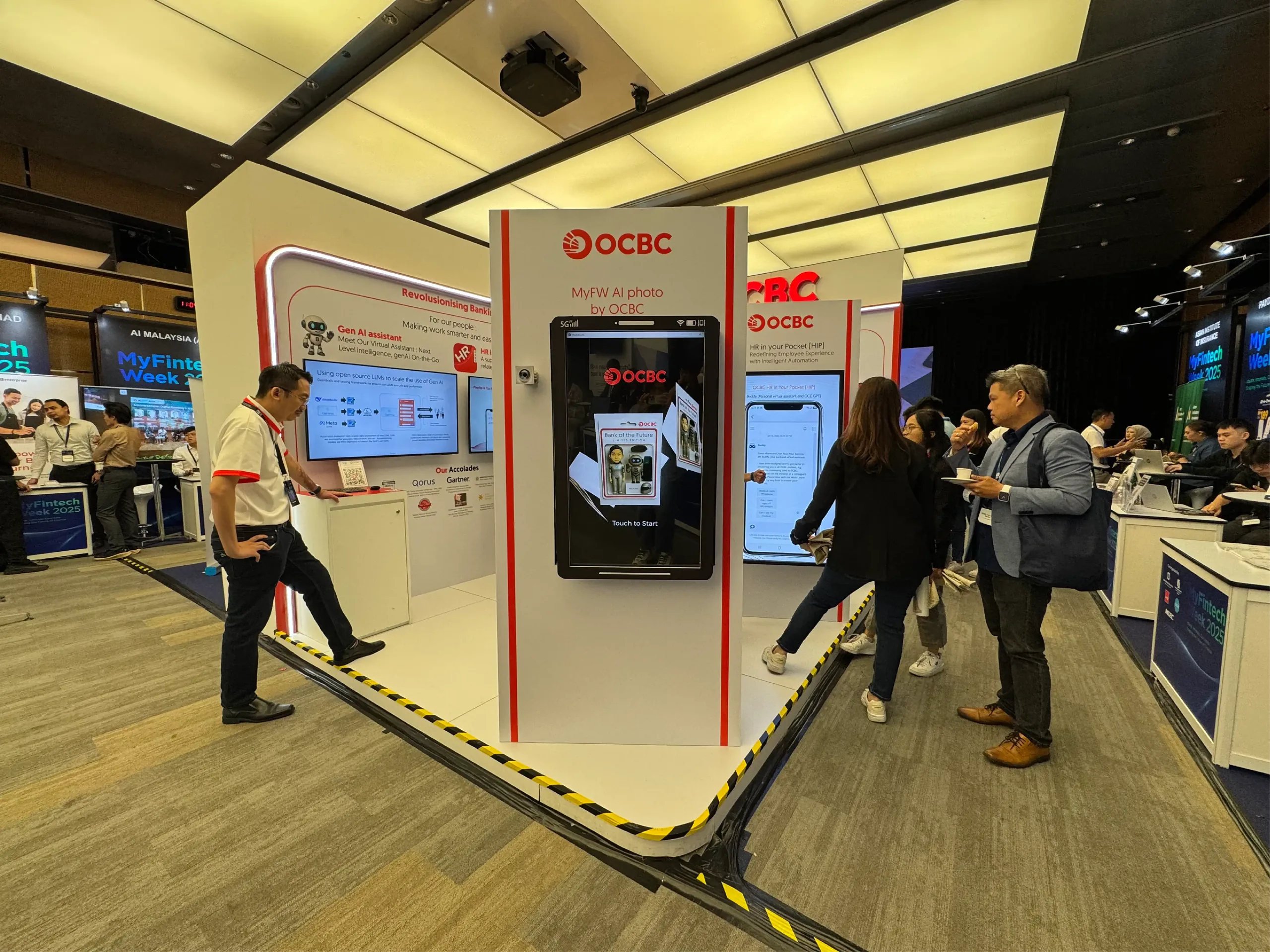 Attendees gather around a branded AI photo kiosk at a banking technology expo booth.