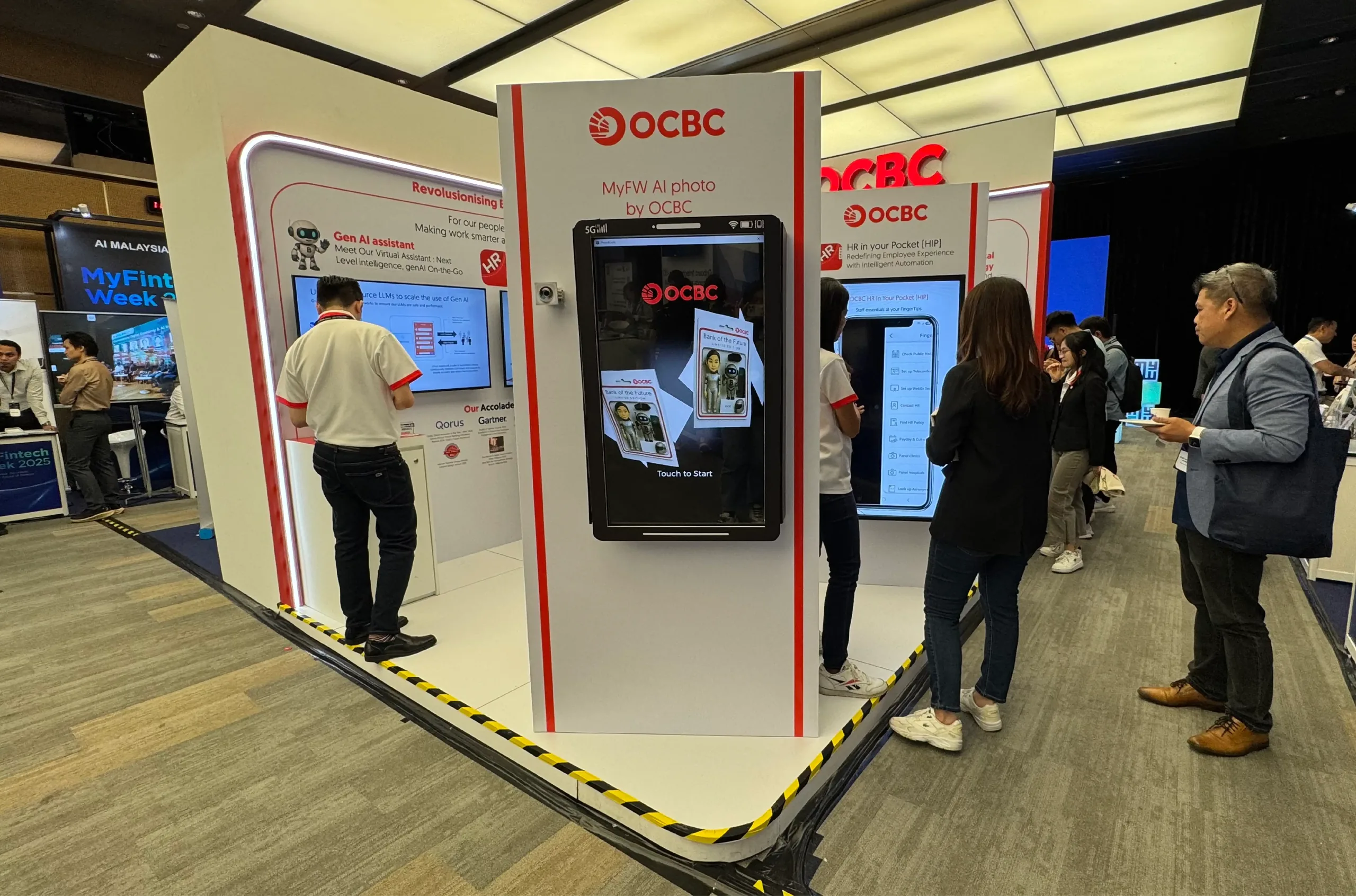 Attendees gather around a branded 'Touch to Start' AI photo kiosk at a banking expo booth.