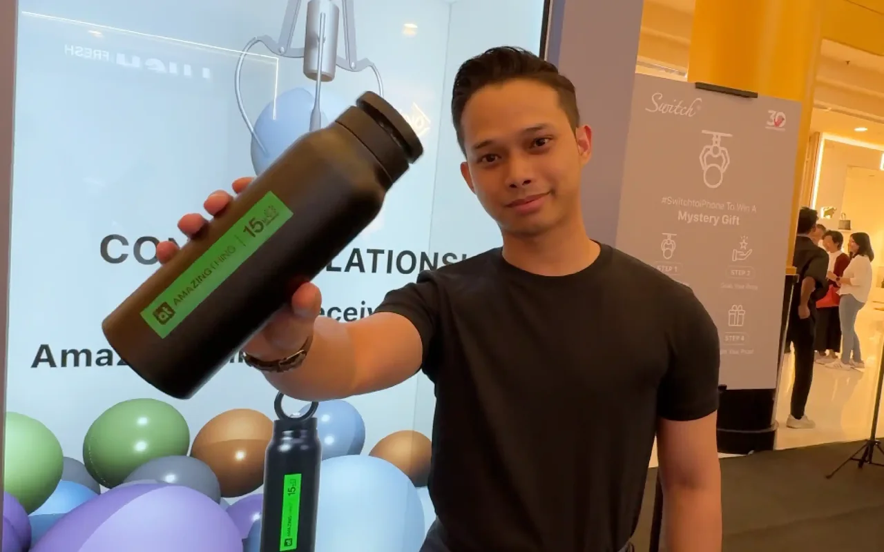 A guest holds up the bottle he won from the Switch digital claw machine at Sunway Pyramid