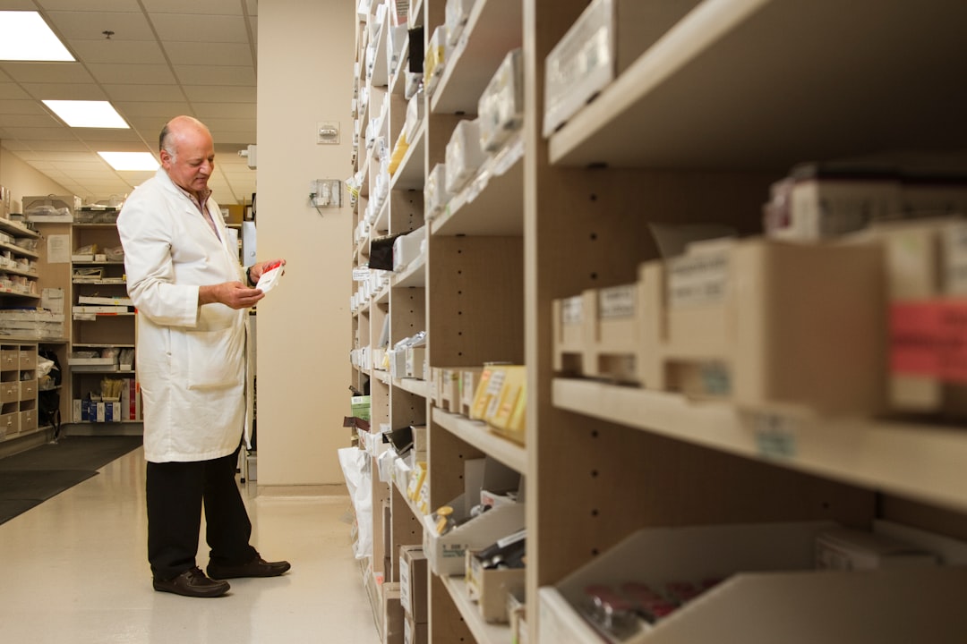 Pharmacist examining a drug from pharmacy shelf inventory