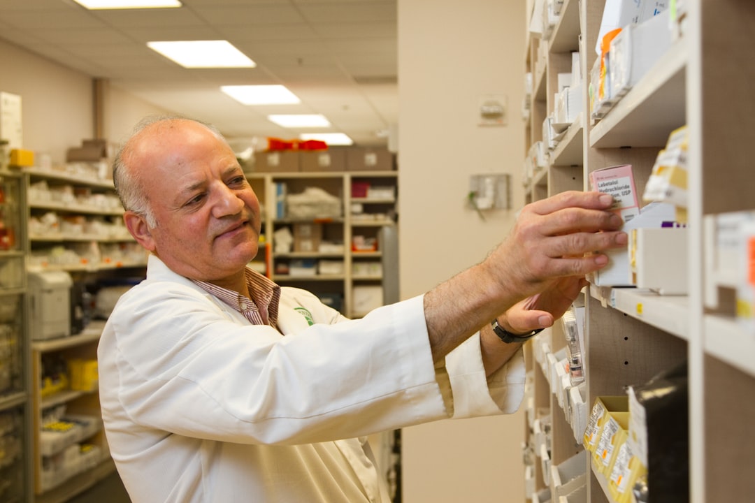 Pharmacist selecting a drug from a pharmacy display case