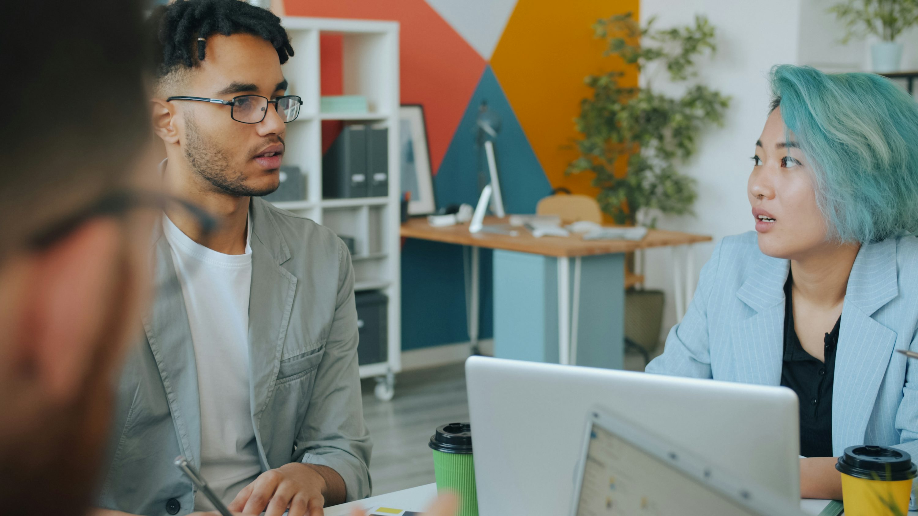 A man and a woman talking during a meeting in a colorful office