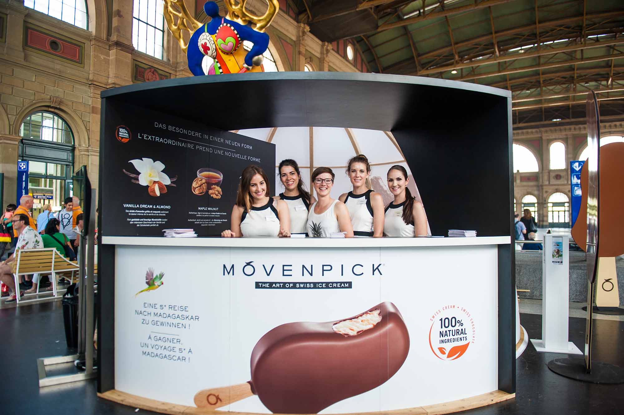 Fünf Frauen in weißen Unternehmensuniformen auf einer Ausstellung