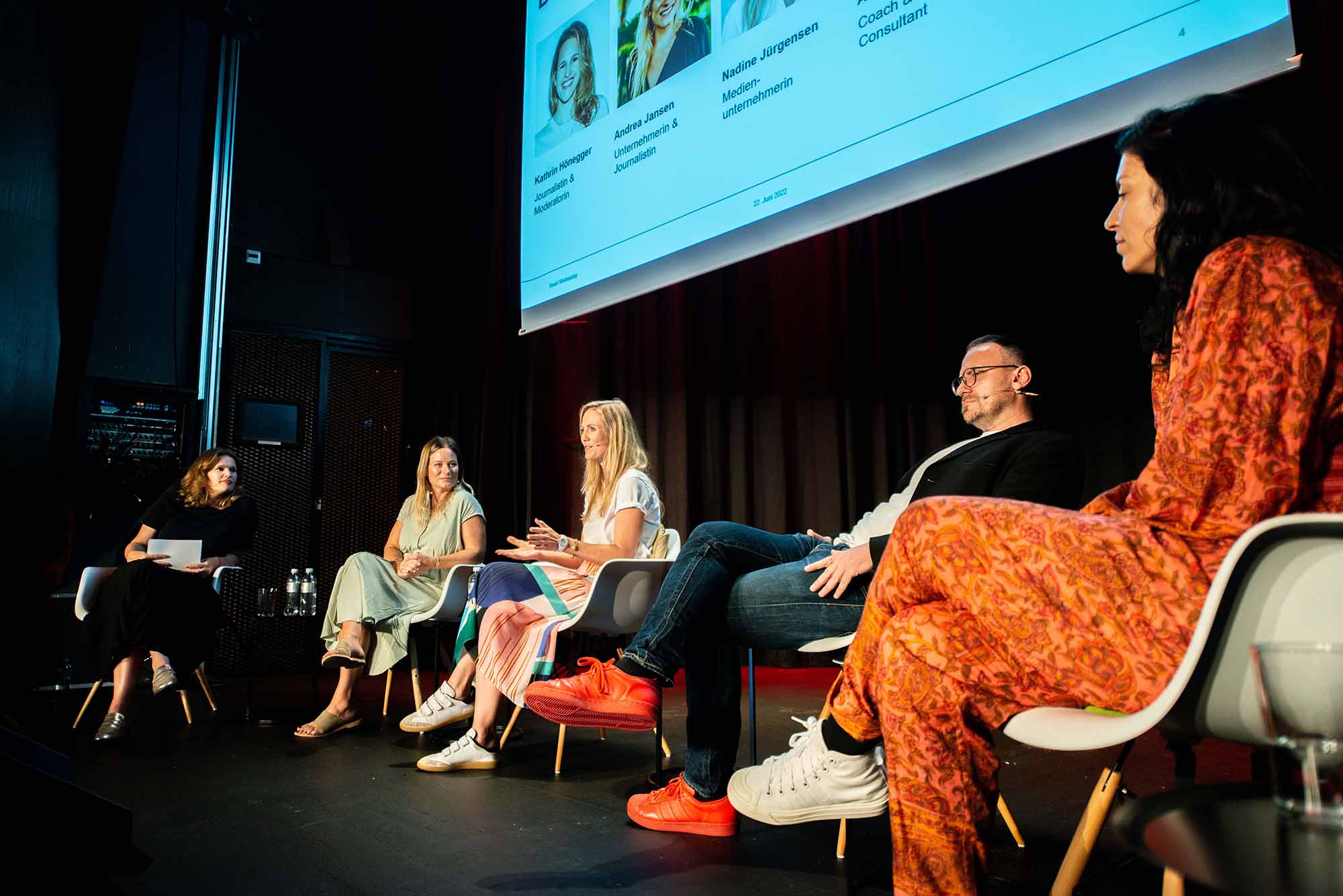 Eine Gruppe von Frauen betritt eine Podiumsdiskussion