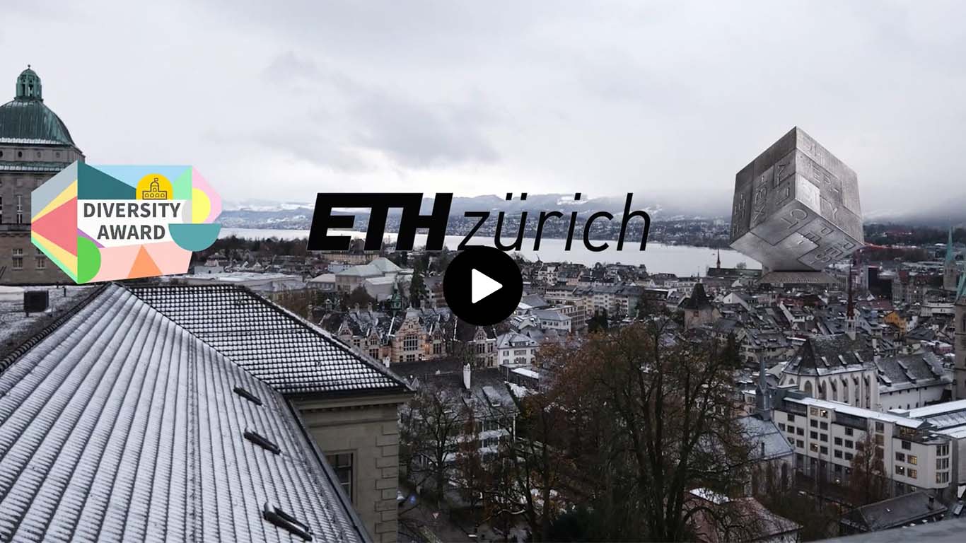 Blick auf das verschneite Dach eines Gebäudes der ETH Zürich mit der Skyline der Stadt Zürich, einem Diversity Award Schriftzug links und einem großen grauen Würfel rechts.