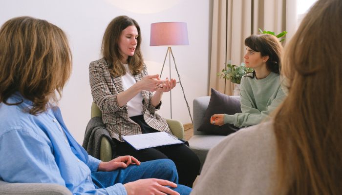 A diverse group of people sitting in a circle, engaged in conversation and sharing ideas with one another.