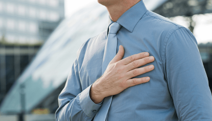 A man in a blue shirt holds his chest, symbolizing the start of a journey to a wholesome mind and body.