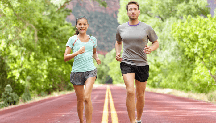 A man and woman jogging together on a road, showcasing an active lifestyle.