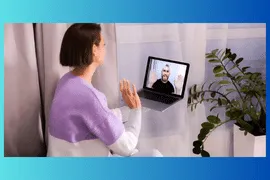 A woman sitting on a couch during a video visits with a provider.