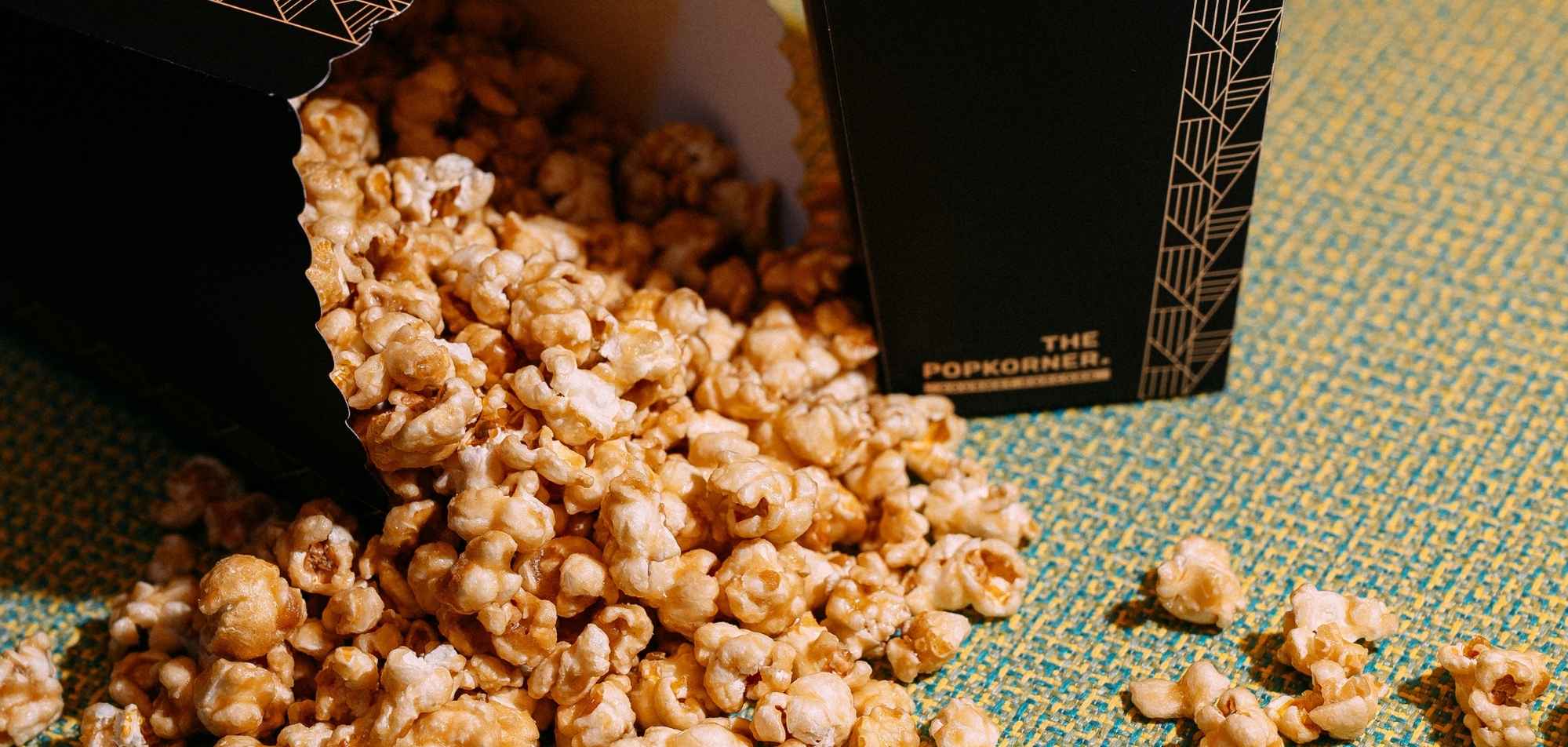 Three young girls sitting in pink salon chairs, enjoying ice cream in a brightly colored room with pink walls and shelves.