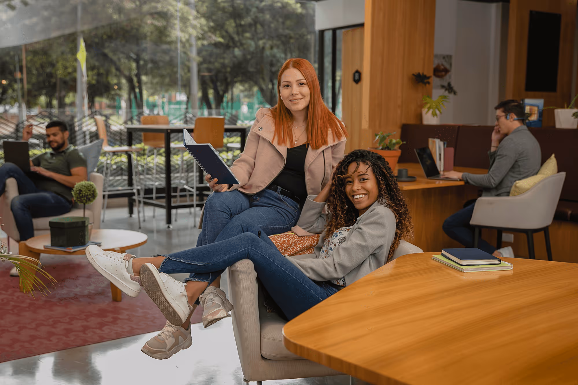 A group of people working around a desk smiling.