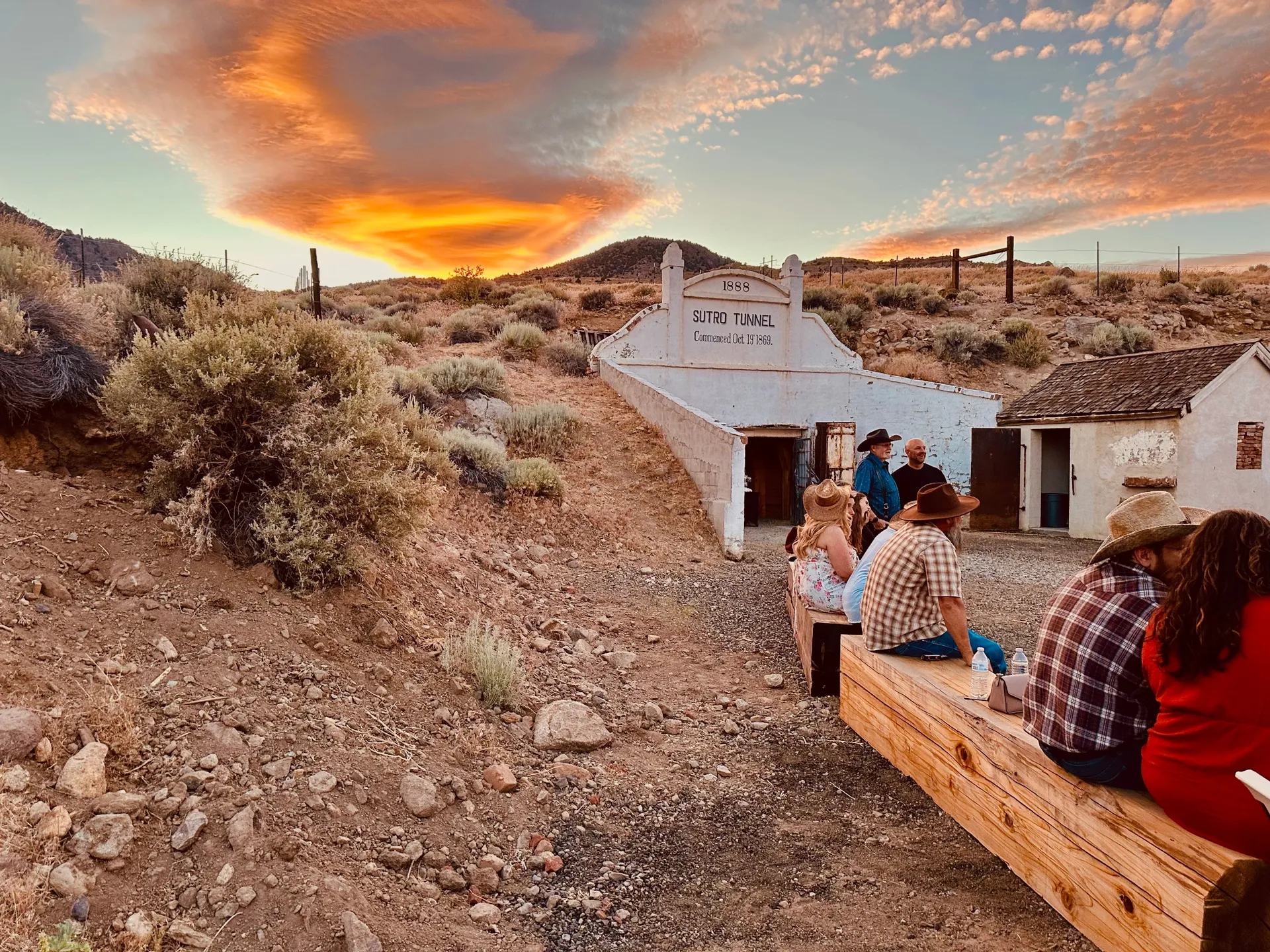 A group of people sitting on top of a wooden bench.