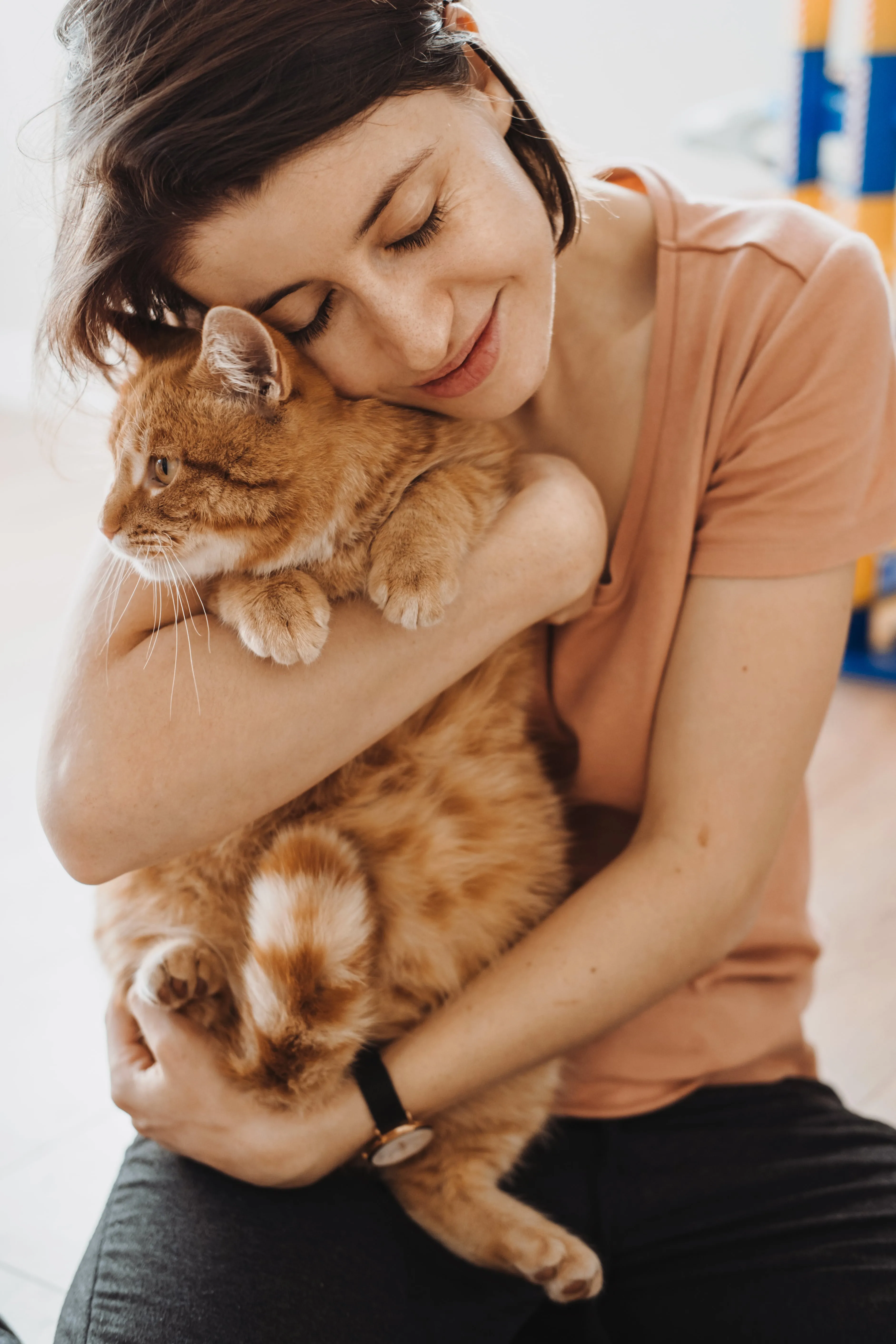 A woman holding a cat in her arms.