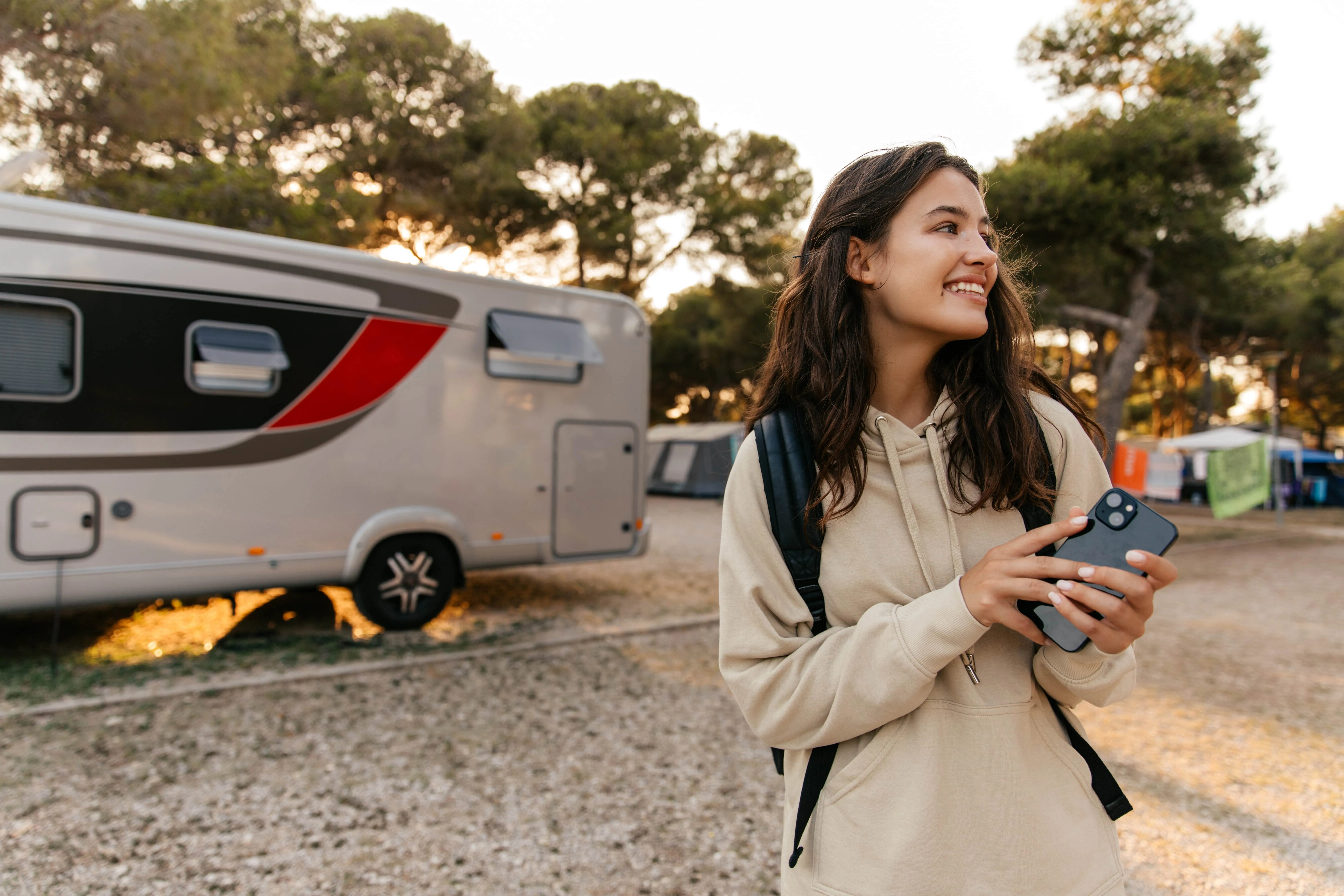 A woman standing in front of a trailer holding a remote control.