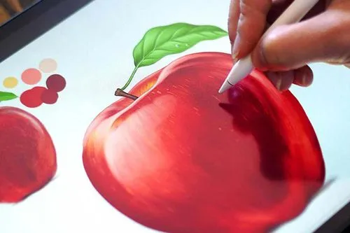 Close-up of a hand using a stylus to digitally paint a red apple with green leaf on a tablet screen.