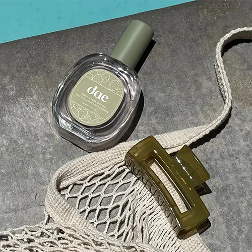 A perfume and hair clip on a table