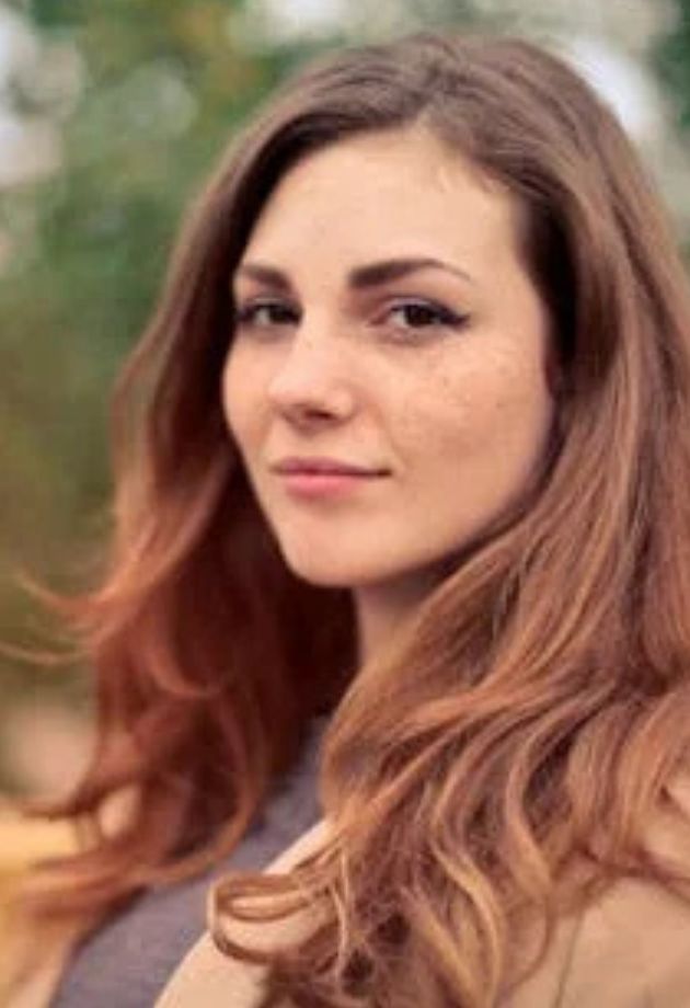 Portrait d'une femme aux cheveux longs et bouclés, avec un fond verdoyant, représentant l'ambiance chaleureuse de L'instant bière
