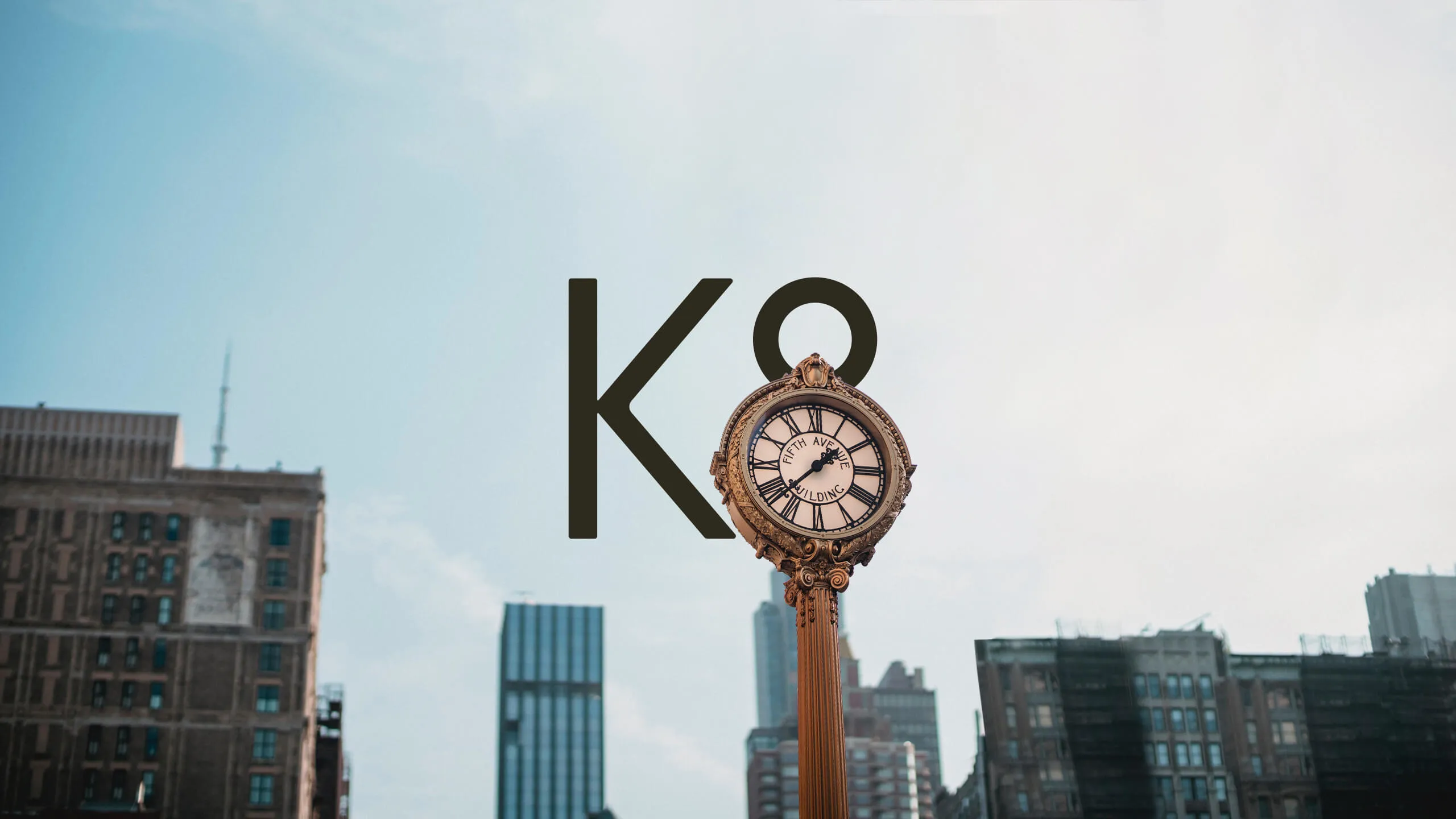 K8 logo in urban environment with a round clock covering half of the 8