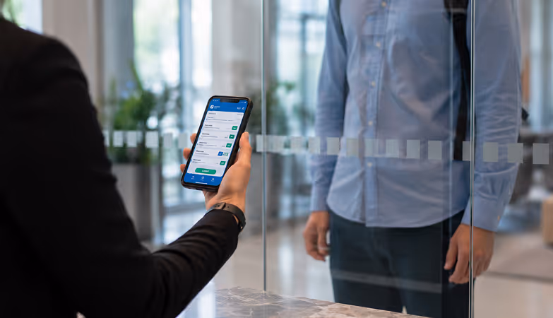 Employee completing a digital health screening checklist on a mobile device before entering the workplace.