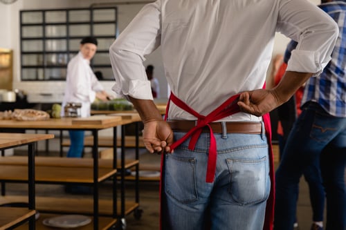 Restaurant Worker Tying Apron in Commercial Kitchen