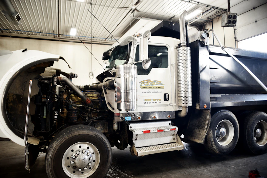 semi truck with its hood up for repair