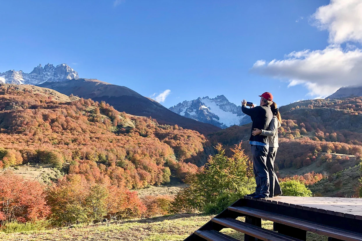 Traveler photographing fall colors and mountain landscapes in Cerro Castillo, Patagonia Chile.