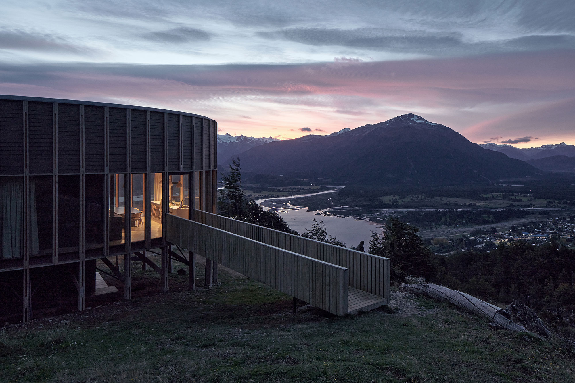 Dramatic interior with exposed concrete ceiling and panoramic lake views at Bahia Murta House