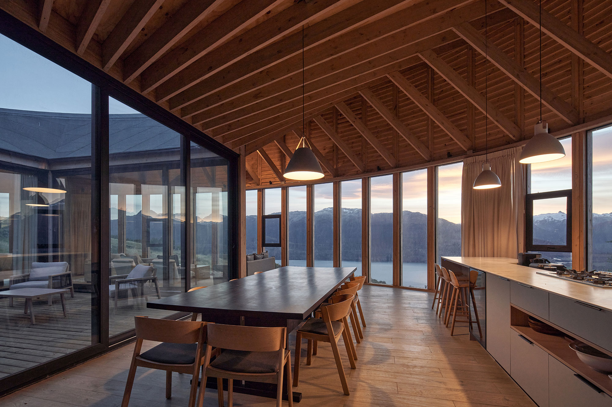 Bedroom with panoramic windows framing Lago General Carrera and snow-capped peaks
