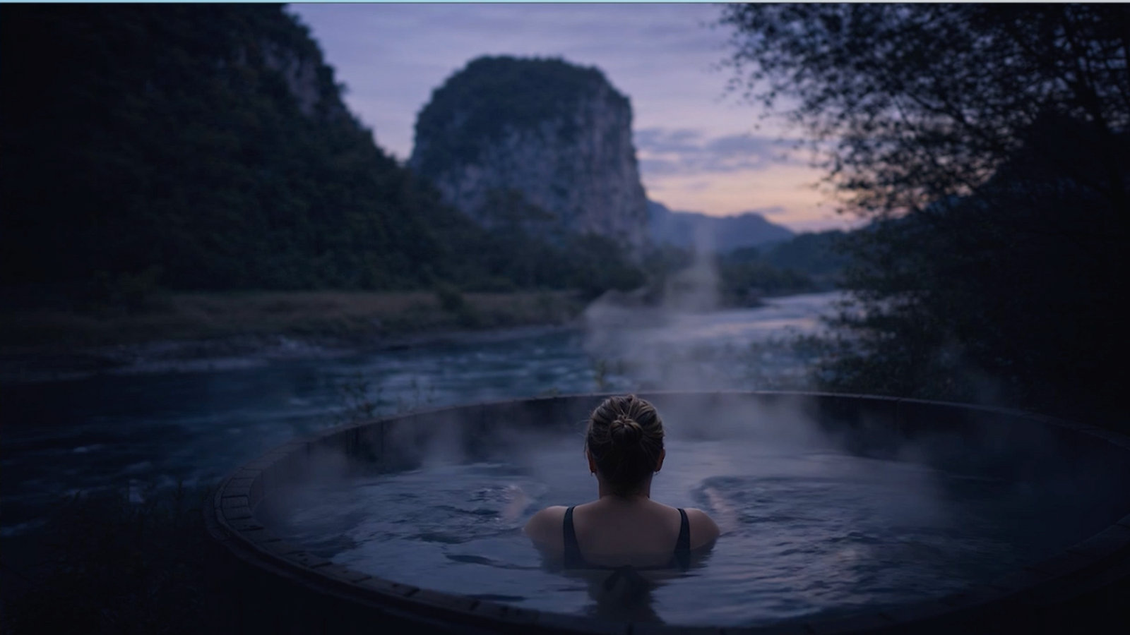 Riverside hot tub at dusk facing the Queque Inglés on the Río Simpson near Coyhaique
