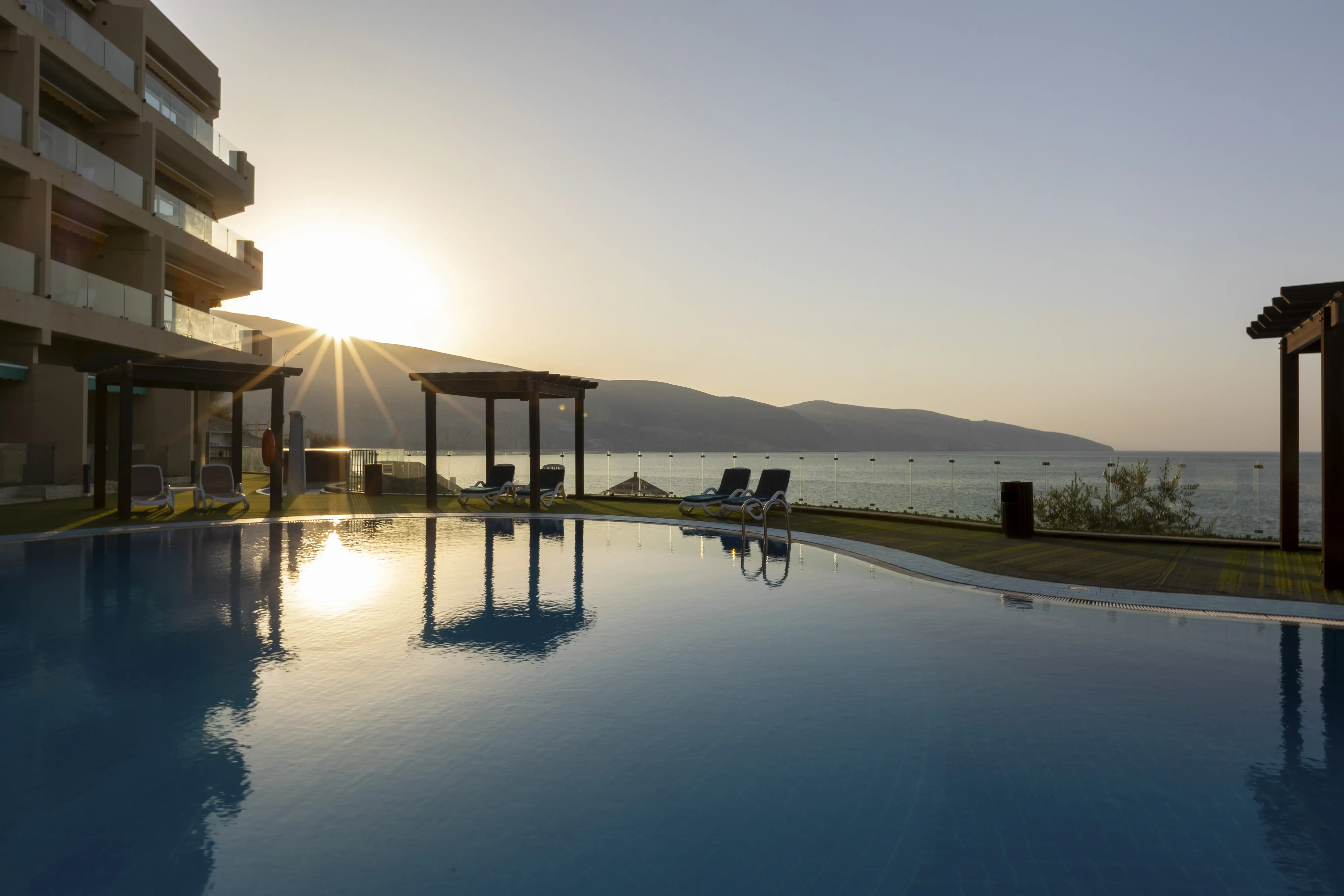 Sunset in the distance, light reflected on the pool at Atana Khasab. 